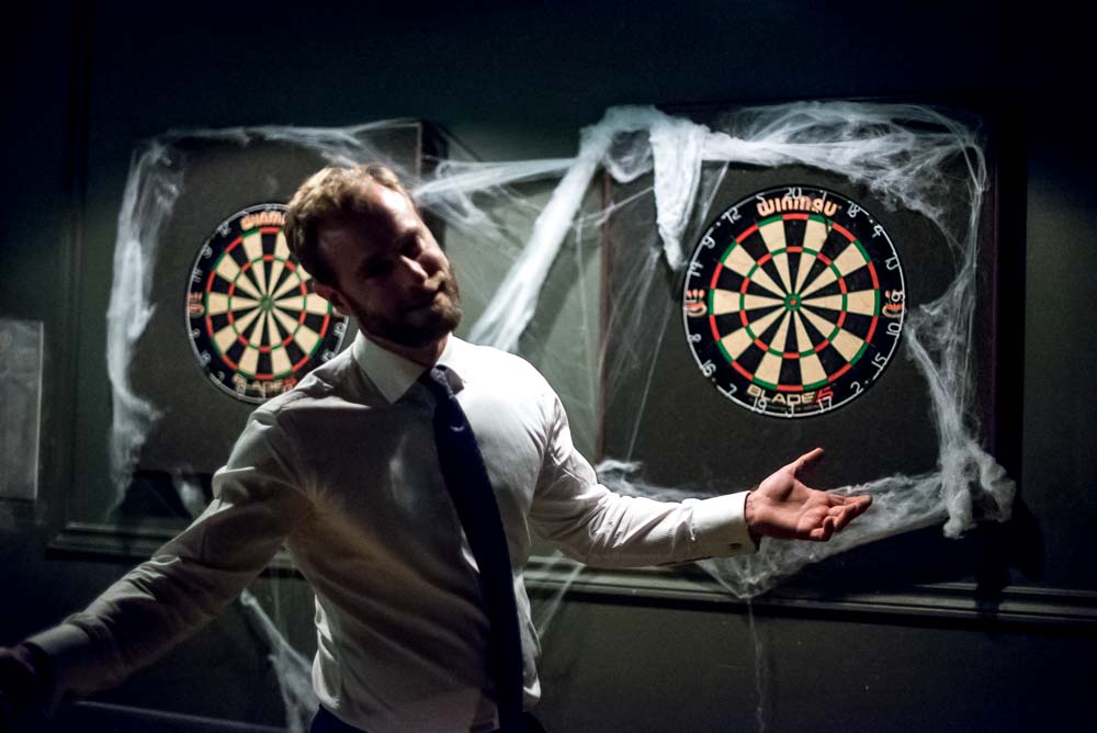 once, a man stood in front of a dart board
